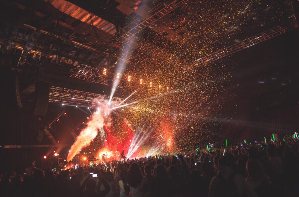 Huge crowd in front of a bright lit stage at a Tokio Hotel concert produced by 1314