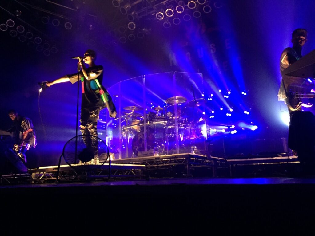 Singer on a blue lit stage at a concert produced by 1314