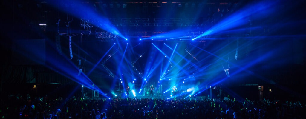 Huge crowd in front of a bright lit stage at a Tokio Hotel concert produced by 1314