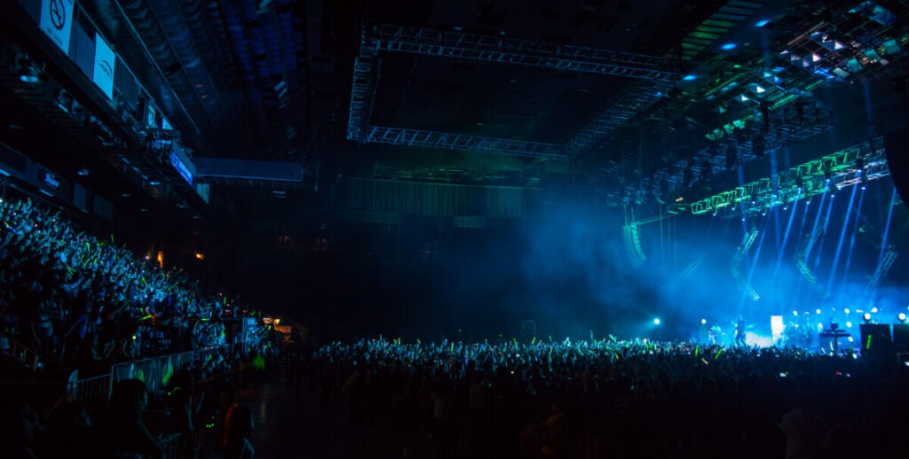 Huge crowd in front of a bright lit stage at a Tokio Hotel concert produced by 1314