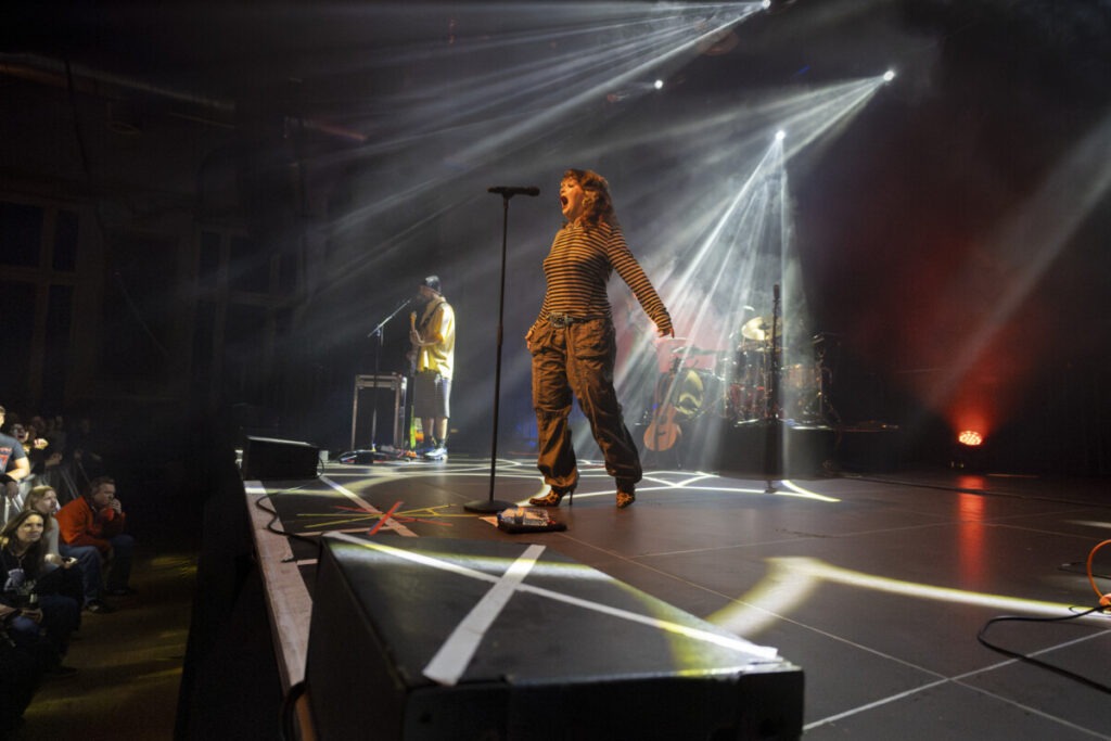 Lola Young singing on stage in Germany