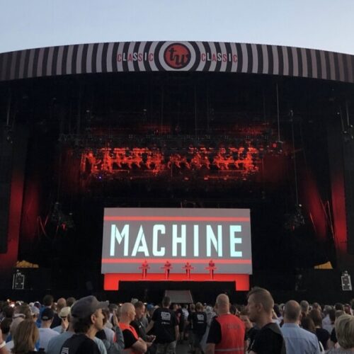 Stage with four people on it of a Kraftwerk concert produced by 1314 in front of a crowd
