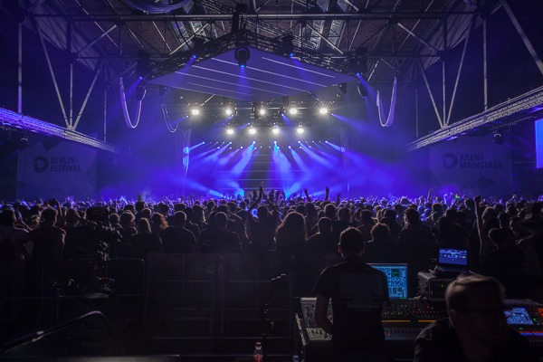 Crowd of people in front of a blue lit stage at the Berlin festival produced by 1314