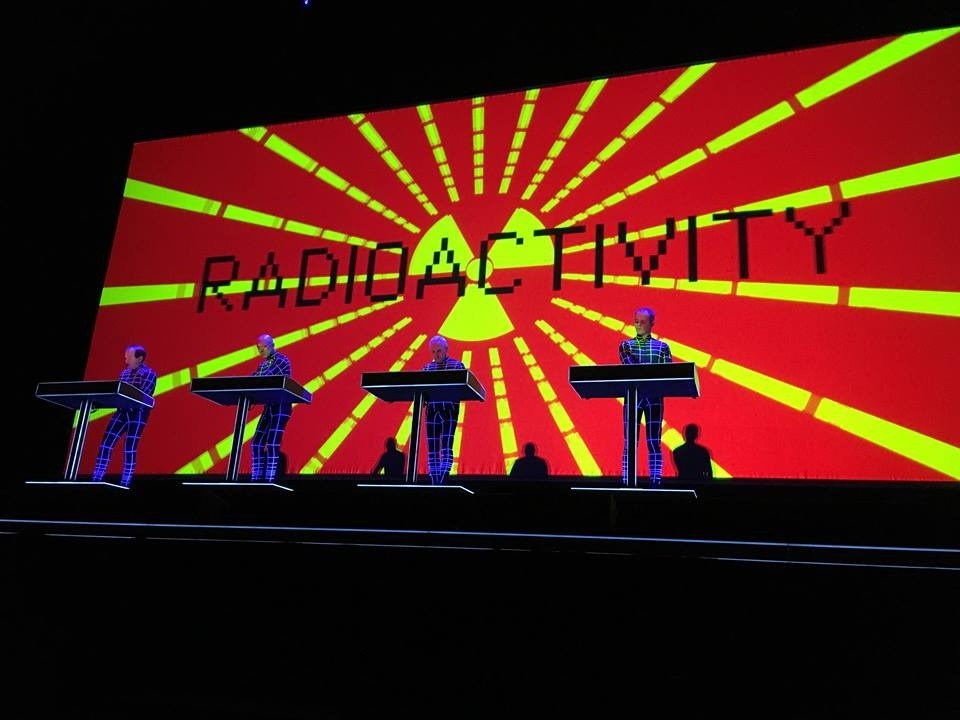Stage with a red Backdrop with four people on it of a Kraftwerk concert produced by 1314