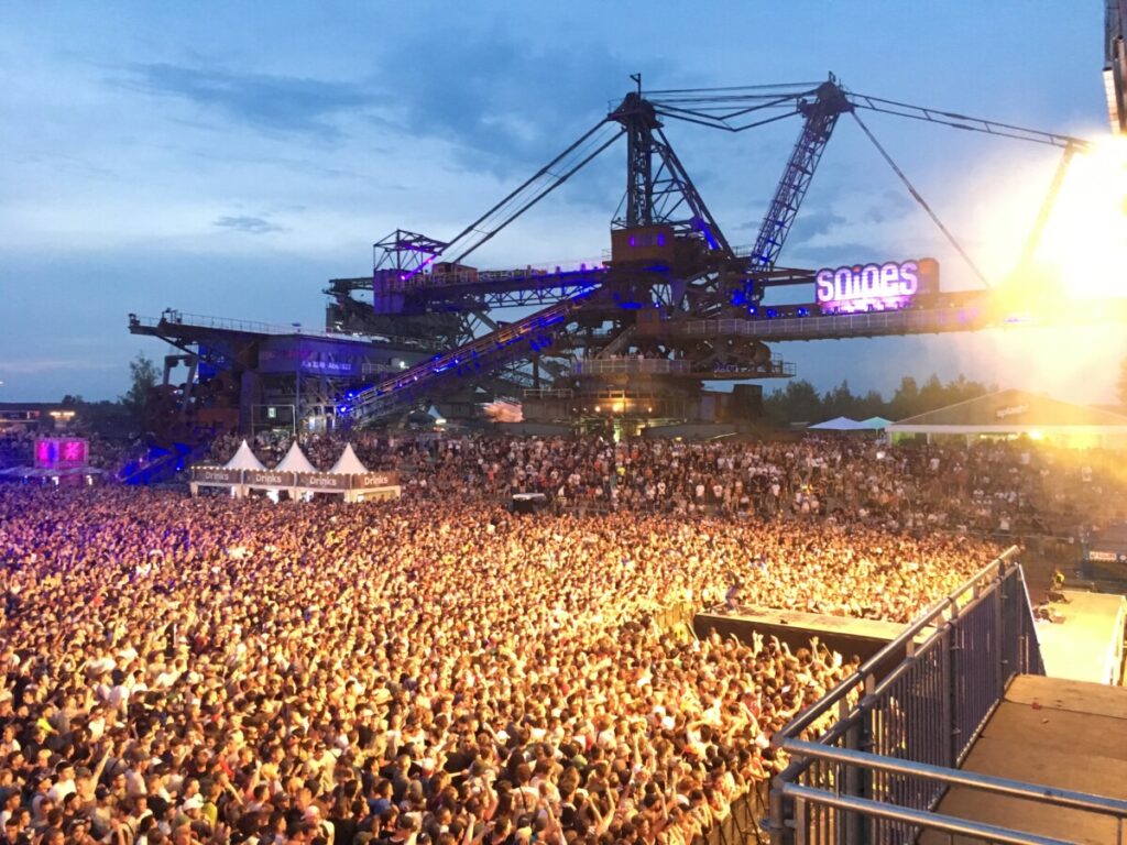 Crowd under a big industrial construction crane at the Splash festival in Germany