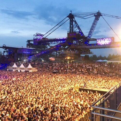 Crowd under a big industrial construction crane at the Splash festival in Germany